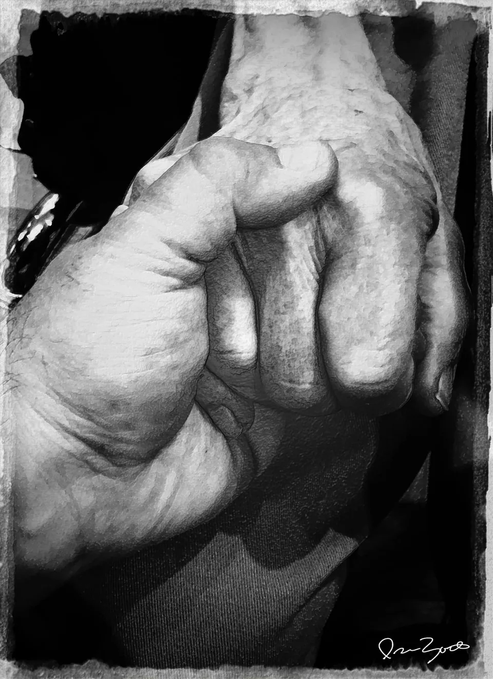 Black and white close-up photograph of an elderly man's closed hand, deeply creased and side-lit against a black background.
